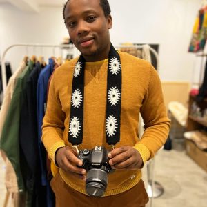 Modèle homme avec une bandoulière noire et blanche pour camera