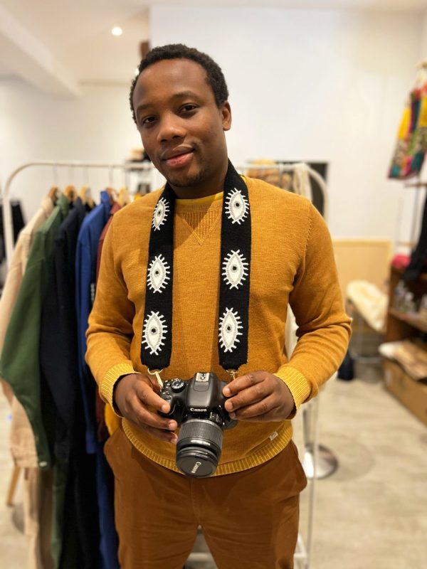 Modèle homme avec une bandoulière noire et blanche pour camera