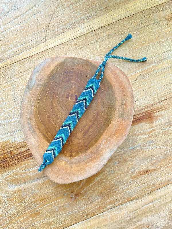Bracelet tissé sur un support en bois